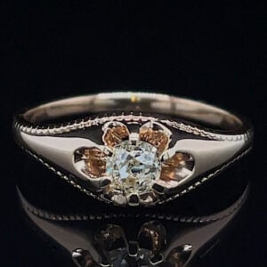 Diamond ring with a central round stone flanked by amber-colored gems in a flower setting on a polished band