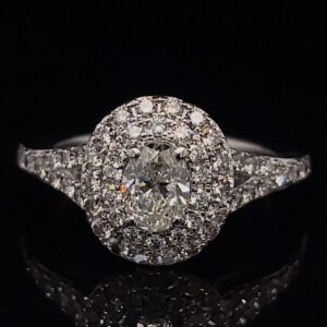 Diamond engagement ring with a central round stone surrounded by a halo of smaller diamonds on a black background.
