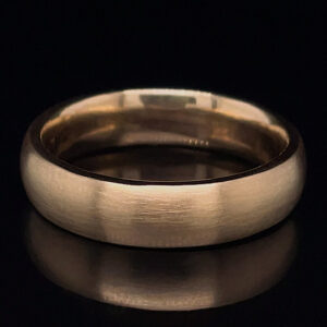 Brushed silver wedding band photographed on a black background, showing its simple, wide metal surface.