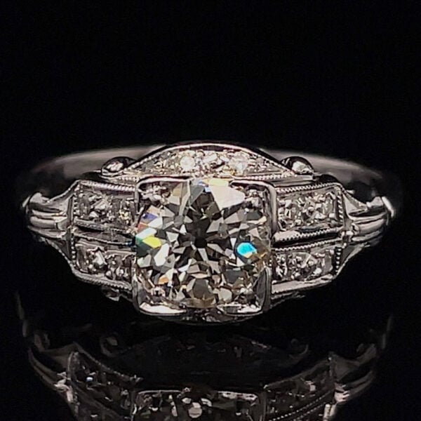 Engagement ring with a large cushion-cut center diamond and pavé side stones in a vintage milgrain platinum setting