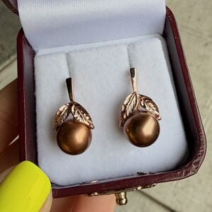 Rose gold drop earrings with brown pearls and leaf accents in a burgundy jewelry box.