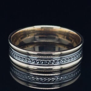 Silver two-band ring with a beaded midsection, photographed on a dark reflective surface